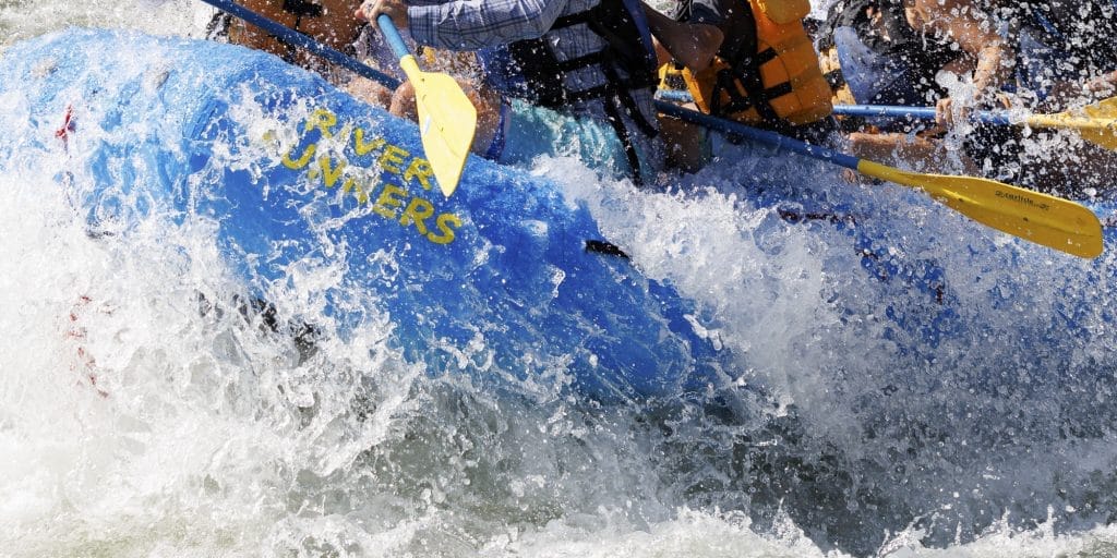 River Runners Raft explodes out of a crashing wave
